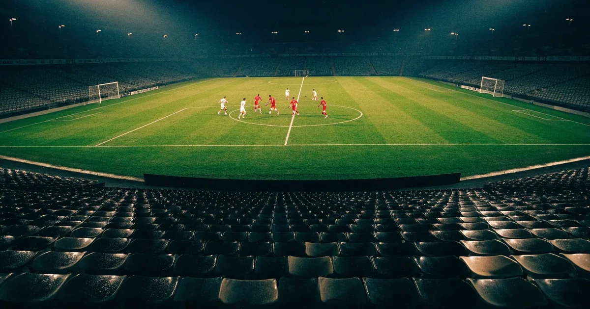 Leere Sitzreihen eines großen Stadions unter Flutlicht, dahinter die ferne Sicht auf den hell beleuchteten Rasen nach Sonnenuntergang.